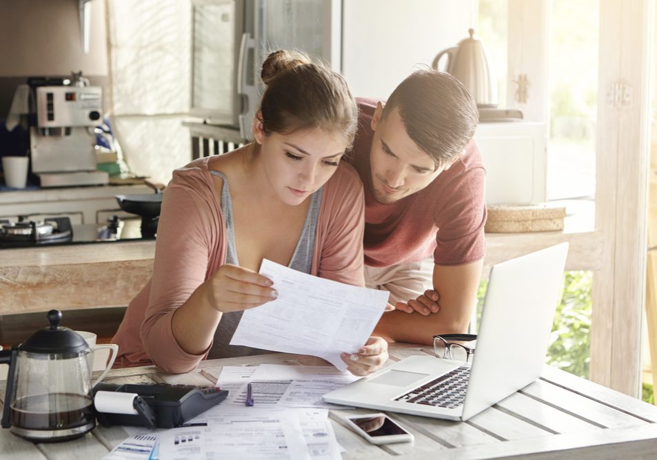 Young,Couple,Managing,Finances,,Reviewing,Their,Bank,Accounts,Using,Laptop