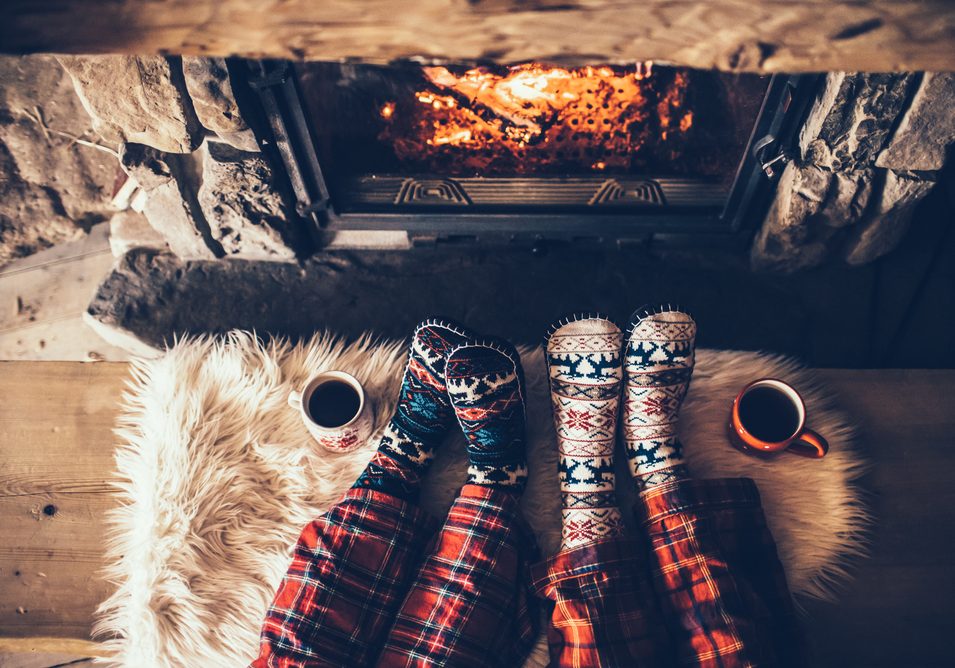 Feet,In,Woollen,Socks,By,The,Christmas,Fireplace.,Couple,Sitting